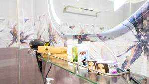 a shelf with cosmetics and a mirror in a bathroom at Tranquil Guest in Sigiriya