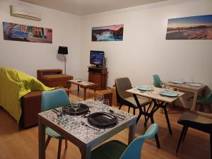 a living room with tables and chairs and a couch at Q1 Blueroom Sofia's Happy Apartment in Loulé