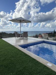 a patio with an umbrella next to a swimming pool at Casa del jazmin Kfarabida in Kafr ‘Ubaydā