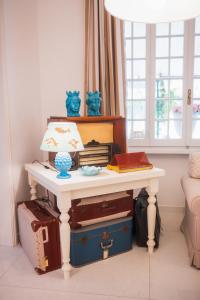 a table with a lamp on top of luggage at Hotel La Pineta Al Mare in Forte dei Marmi