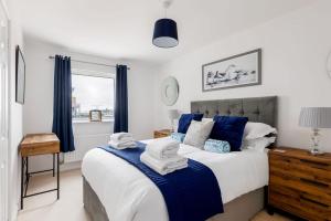 a bedroom with a large bed with blue accents at Harbourside Retreat - Spacious Balcony with Harbour Views in Poole