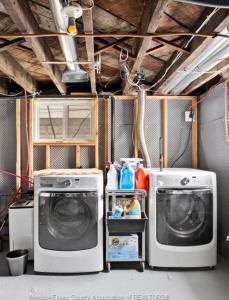 a laundry room with two washing machines in it at Hidden Gem Steps From River, Restos, Cafés, Parks in Windsor