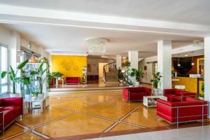 a lobby with red couches and potted plants at Hotel Palace Magnolia SPA in Tortoreto Lido