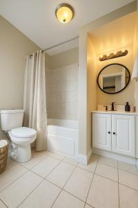 a bathroom with a toilet and a tub and a sink at Hidden Gem Steps From River, Restos, Cafés, Parks in Windsor +15 photos