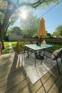 a patio with a table and an umbrella on a deck at Hidden Gem Steps From River, Restos, Cafés, Parks in Windsor