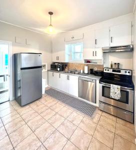 a kitchen with white cabinets and stainless steel appliances at Hidden Gem Steps From River, Restos, Cafés, Parks in Windsor