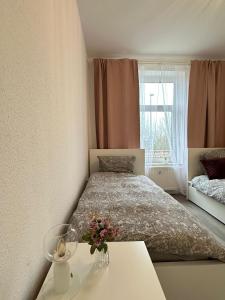 a bedroom with a bed and a table with flowers on it at Apartments Brunsbüttel 2 in Brunsbüttel