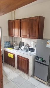 a kitchen with wooden cabinets and a refrigerator at Résidence PAYAN in Douala