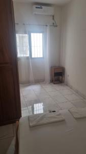 a white room with a bed and a window at Résidence PAYAN in Douala +2 photos