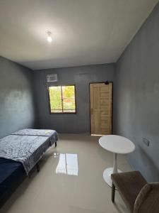 a bedroom with a bed and a table and a window at Evas Inn in General Santos