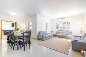 a dining room and living room with a table and chairs at Villa Trobadors in El Arenal +22 photos