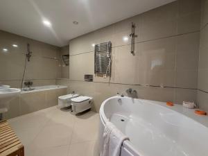 a bathroom with a tub and a toilet and a sink at Apartment A36 Silver Mountain in Poiana Brasov +32 photos
