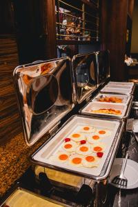a buffet with three trays of food on a table at Dabas Hotel in Dabas