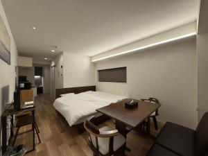 a bedroom with a bed and a table and a tv at Tiz wan hotel in Sumoto