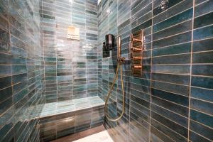 a bathroom with a shower with blue tiled walls at Locanda Alberti in Mandello del Lario +65 photos