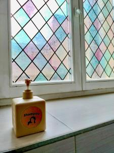 a container of shampoo sitting on a window sill at Hostel Alfar in Sarajevo +15 photos