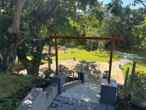 a wooden arch in a park with a tree at Bellevue Guest Lodge in Southbroom +8 photos