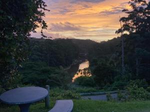 a view of a river at sunset with a bench at Bellevue Guest Lodge in Southbroom