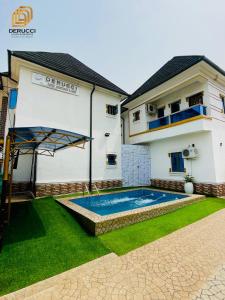a villa with a swimming pool and a house at Derucci Luxury Apartment in Owerri