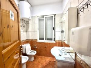 a bathroom with a white toilet and a sink at PMG Hostel in Tirana +17 photos