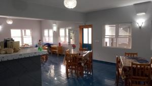 a kitchen and dining room with tables and chairs at Djabraba's Rooms in Vila Nova Sintra