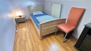 a small bedroom with a bed and a chair at A&K Guest House in Sandweiler +28 photos