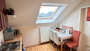 a kitchen with a table with chairs and a window at A&K Guest House in Sandweiler