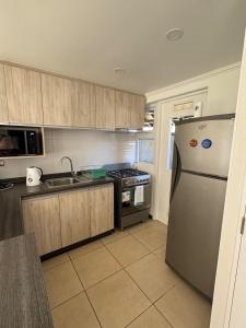 a kitchen with a stainless steel refrigerator and a stove at Pucon, casa condominio in Pucón