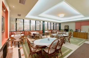 a dining room with tables and chairs and windows at Agriani Hotel - Xanthi Pool & Mountain Views in Xanthi