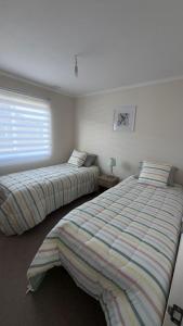 a bedroom with two beds and a window at Pucon, casa condominio in Pucón