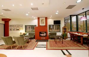 a living room with a fireplace and a dining room at Agriani Hotel - Xanthi Pool & Mountain Views in Xanthi +18 photos