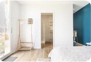 a bedroom with a bed and a blue wall at L’Orée des Vignes in Saint-Sulpice-de-Faleyrens