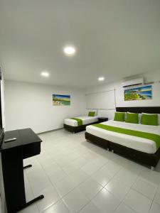 a room with two beds and a desk in it at Hotel Portofino in San Andrés