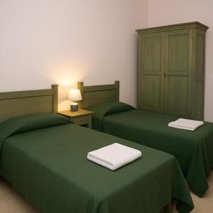 two green beds with green covers in a room at Casa Vacanze Orosei in Orosei