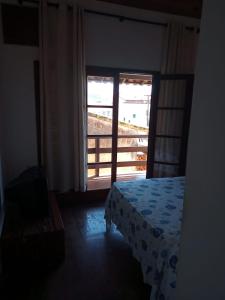a bedroom with a bed and a large window at Duplex 400 meters from Peró Beach in Cabo Frio