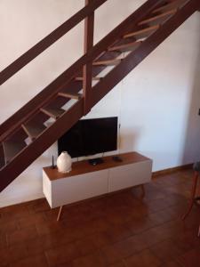 a living room with a tv on a cabinet under a loft bed at Duplex 400 meters from Peró Beach in Cabo Frio