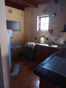 a kitchen with a sink and a stove and a window at Duplex 400 meters from Peró Beach in Cabo Frio