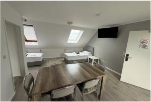 ein Zimmer mit Tisch und Stühlen und zwei Betten in der Unterkunft Swetis Passage in Pulheim
