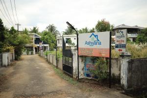 a sign on a fence in front of a house at Ashiyana Homes in Nedumbassery