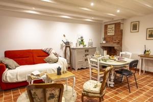 a living room with a red couch and a table at chez Thérèse in Auxonne