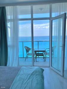 a bedroom with a bed and a view of the ocean at Batumi in the waves in Batumi