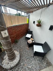 a patio with chairs and a table and a building at Casa de Aire Ezeiza in La Unión