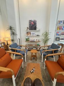 a living room with orange and blue chairs and a table at Bubble Humble Bangkok By Canal in Bangkok
