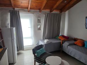 a room with two beds and a table and a chair at CORDOBA AEROPUERTO KEMPES QUORUM HOSPITAL ALLENDE PRIVADO Siglo XXI Universidad PASCAL Templo Mormon de Villa Belgrano in Córdoba
