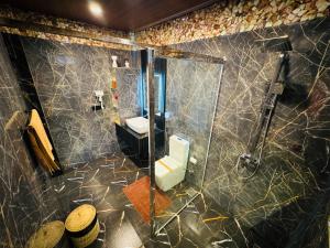a bathroom with a shower with a toilet and a sink at Home Away Ella in Ella