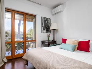 a bedroom with a large white bed with colorful pillows at La Perla Rara in Sant'Agnello