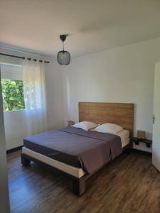 a bedroom with a large bed with a wooden headboard at Éden Évasion in Sainte-Rose +23 photos