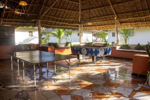 a restaurant with tables and couches in a room at Reef & Beach Resort - Spa Jambiani in Jambiani