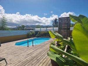 a deck with a swimming pool on top of a building at Éden Évasion in Sainte-Rose