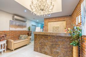 a lobby with a brick wall and a chandelier at Hotel Boutique ADAZ in Santa Marta +22 photos